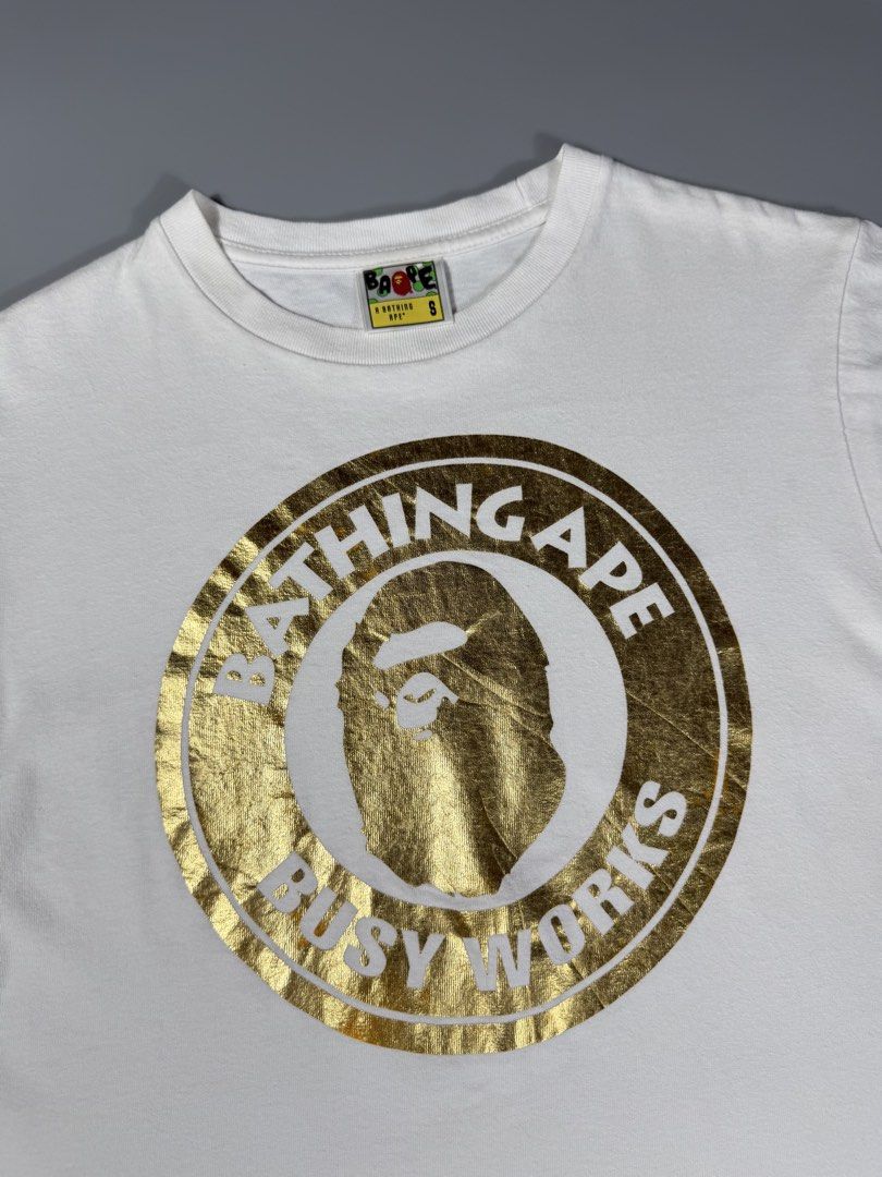 Bape Busy Works Gold Circle Logo Tee White (Category: Tshirts & Polo Shirts ) located in Manila. Submitted by whowearsstreetwear (Listing ID 1460482941, Image 2). Description: Bape Busy Works Gold Circle Logo Tee White (Authentic) - Size: Small on tag (measurements in inches) W - 19 L - 25 Condition: Excellent Flaw/s: minor stain only + shipping fee Location: Manila (Near UST).