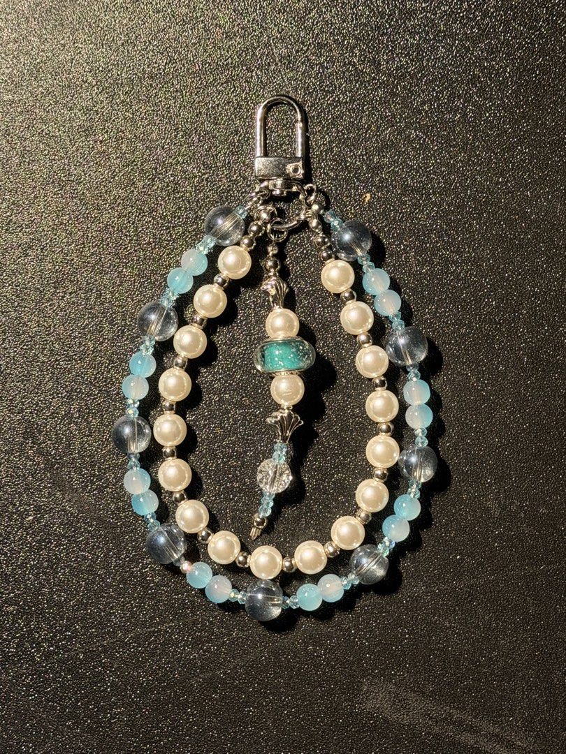 Beaded Keychain with Pearls and Blue Beads (Category: Handmade Craft) located in Manila. Submitted by regyangzon85477 (Listing ID 1460310261, Image 1). Description: - Handmade beaded keychain - Features pearl-like beads and light blue accent beads - Unique central teal bead with glitter - Silver-tone clasp - Ideal for personalizing bags or keys - A unique accessory to stand out.