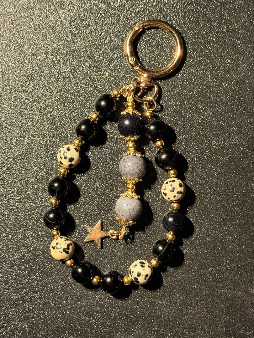Beaded Keychain with Star Charm (Category: Charms) located in Manila. Submitted by regyangzon85477 (Listing ID 1460310872, Image 1). Description: - Adorable handmade beaded keychain. - Features a mix of black, dalmatian jasper, and blue speckled beads. - Accented with a shiny gold star charm. - Equipped with a secure gold clasp for easy attachment. - Ideal accessory for your keys or bags..