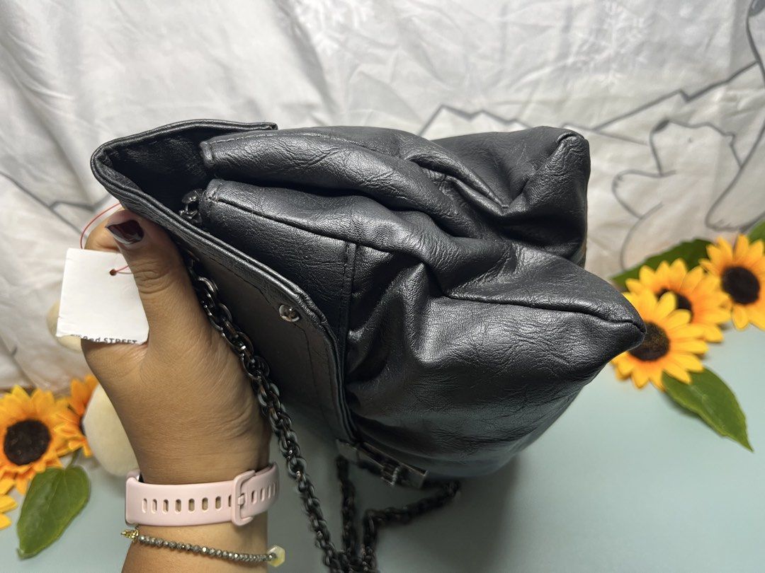 Black Faux Leather Chain Shoulder Bag (Category: Shoulder Bags) located in Liloan. Submitted by sakurumifinds2809 (Listing ID 1460351086, Image 3). Description: - Stylish black shoulder bag - Features a chunky silver chain strap - Made from soft, slightly crinkled faux leather - Secure flap closure with a twist lock - Ample space for your essentials - Versatile for casual outings and evening events.