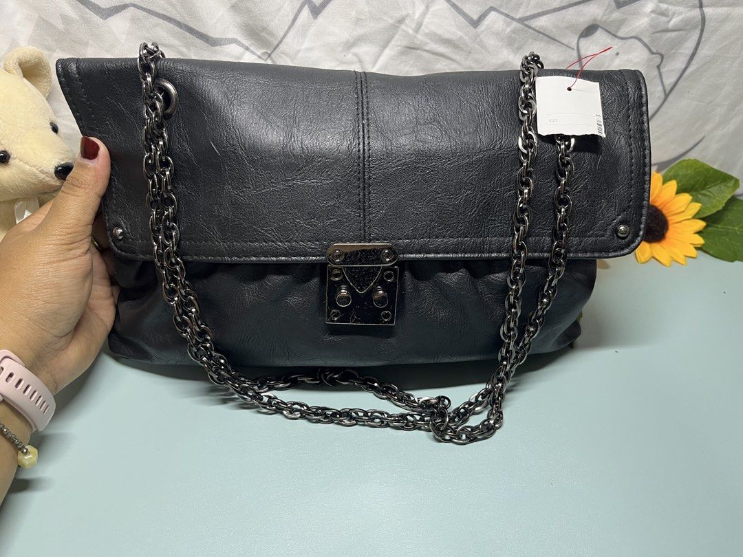 Black Faux Leather Chain Shoulder Bag (Category: Shoulder Bags) located in Liloan. Submitted by sakurumifinds2809 (Listing ID 1460351086, Image 1). Description: - Stylish black shoulder bag - Features a chunky silver chain strap - Made from soft, slightly crinkled faux leather - Secure flap closure with a twist lock - Ample space for your essentials - Versatile for casual outings and evening events.