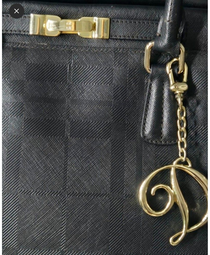 Black Textured Handbag with Gold Charm (Category: Other Accessories) located in Quezon City. Submitted by affordabags_cd (Listing ID 1460426604, Image 2). Description: - Classic black handbag with a subtle textured pattern. - Elegant gold hardware and decorative 'D' charm. - Comfortable top handles for easy carrying. - Protective gold studs on the bottom to prevent wear. - Versatile for both everyday use and special events..