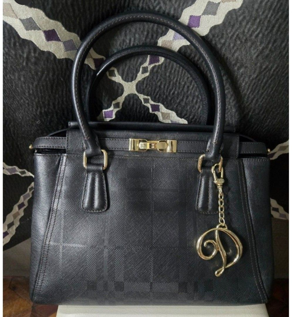 Black Textured Handbag with Gold Charm (Category: Other Accessories) located in Quezon City. Submitted by affordabags_cd (Listing ID 1460426604, Image 1). Description: - Classic black handbag with a subtle textured pattern. - Elegant gold hardware and decorative 'D' charm. - Comfortable top handles for easy carrying. - Protective gold studs on the bottom to prevent wear. - Versatile for both everyday use and special events..