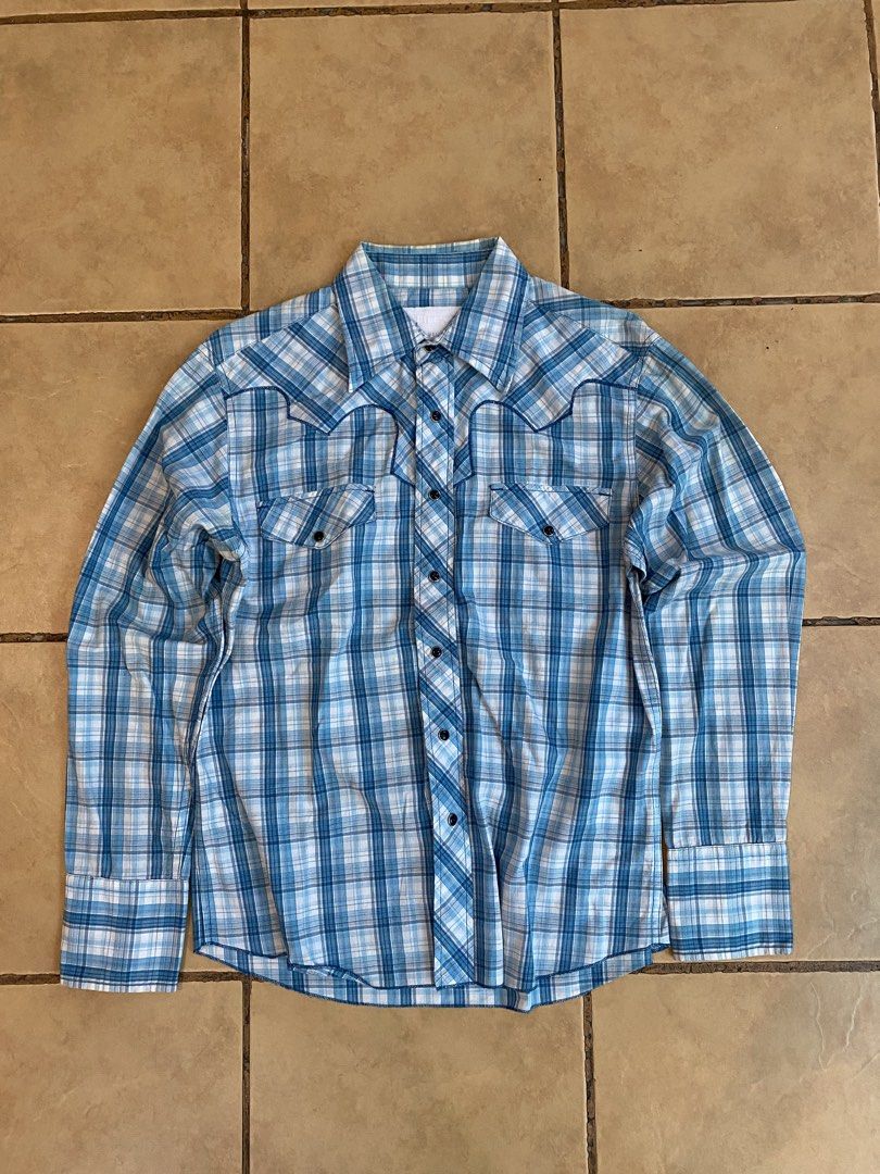 Blue Plaid Western Style Button-Up Shirt - Medium (Category: Tshirts & Polo Shirts ) located in Manila. Submitted by sebthrift (Listing ID 1460358520, Image 1). Description: - Classic blue and white plaid long-sleeve shirt - Western style with snap buttons - Two chest pockets - Brand: BRETT - Size: MEDIUM - Ideal for casual wear.