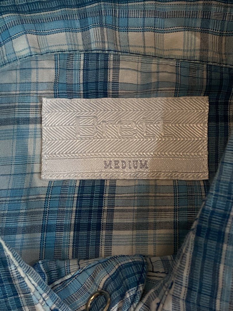 Blue Plaid Western Style Button-Up Shirt - Medium (Category: Tshirts & Polo Shirts ) located in Manila. Submitted by sebthrift (Listing ID 1460358520, Image 2). Description: - Classic blue and white plaid long-sleeve shirt - Western style with snap buttons - Two chest pockets - Brand: BRETT - Size: MEDIUM - Ideal for casual wear.