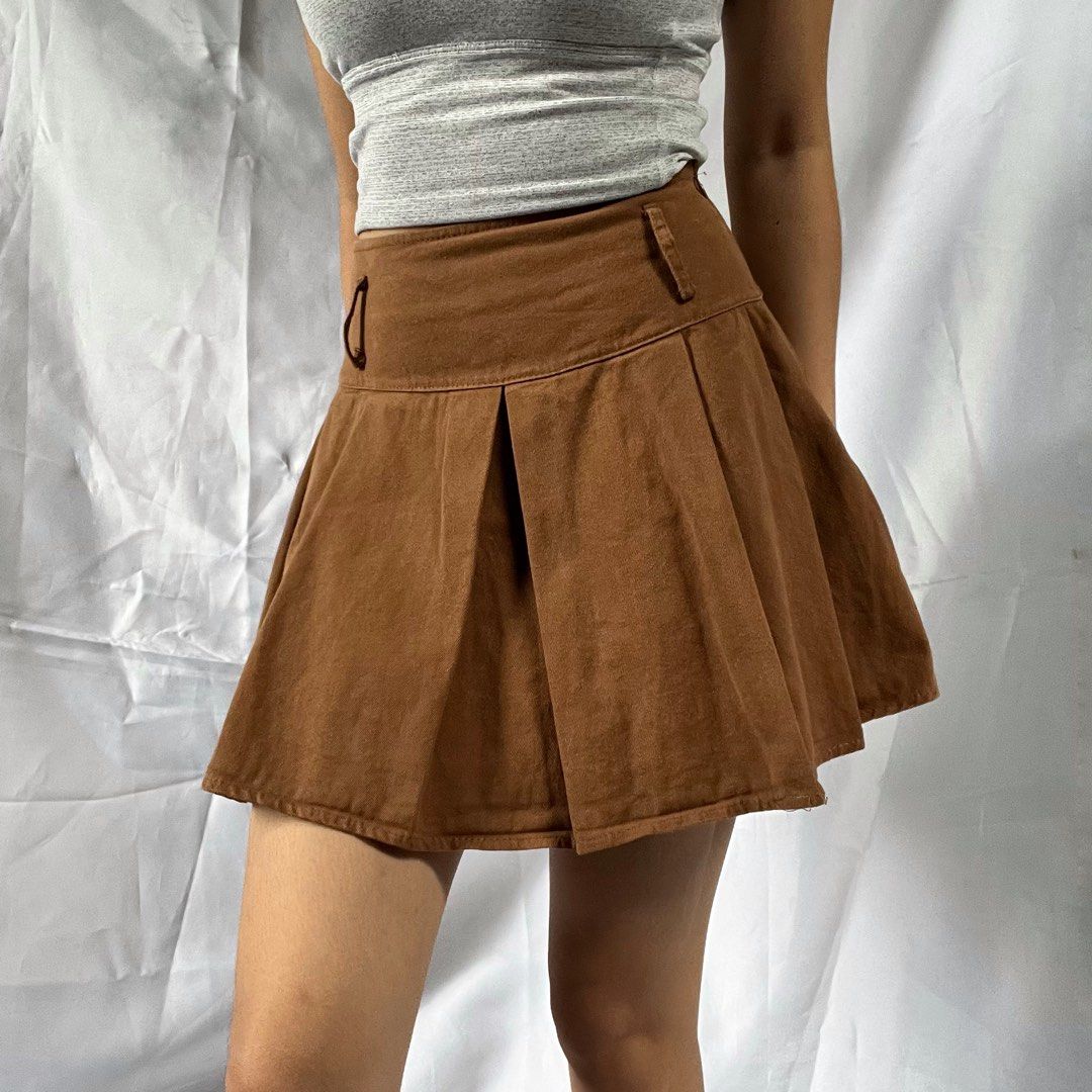 Brown Pleated Mini Skirt with Shorts Underlay (Category: Skirts) located in Manila. Submitted by demi.rewears (Listing ID 1460314210, Image 2). Description: Cute brown pleated mini skirt with built-in shorts. Soft suede/corduroy-like fabric with unique button detail. Perfect for casual or dressed-up looks! Size: Fits Extra Small (XS) Waist: Fits 22” to 24” (11.5” flat lay) Length: 14” (Micro mini length).