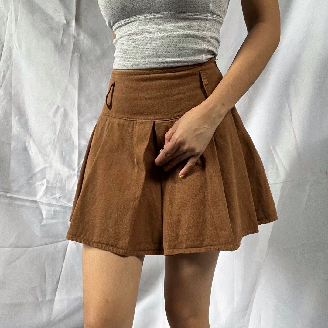 Brown Pleated Mini Skirt with Shorts Underlay (Category: Skirts) located in Manila. Submitted by demi.rewears (Listing ID 1460314210, Image 1). Description: Cute brown pleated mini skirt with built-in shorts. Soft suede/corduroy-like fabric with unique button detail. Perfect for casual or dressed-up looks! Size: Fits Extra Small (XS) Waist: Fits 22” to 24” (11.5” flat lay) Length: 14” (Micro mini length).