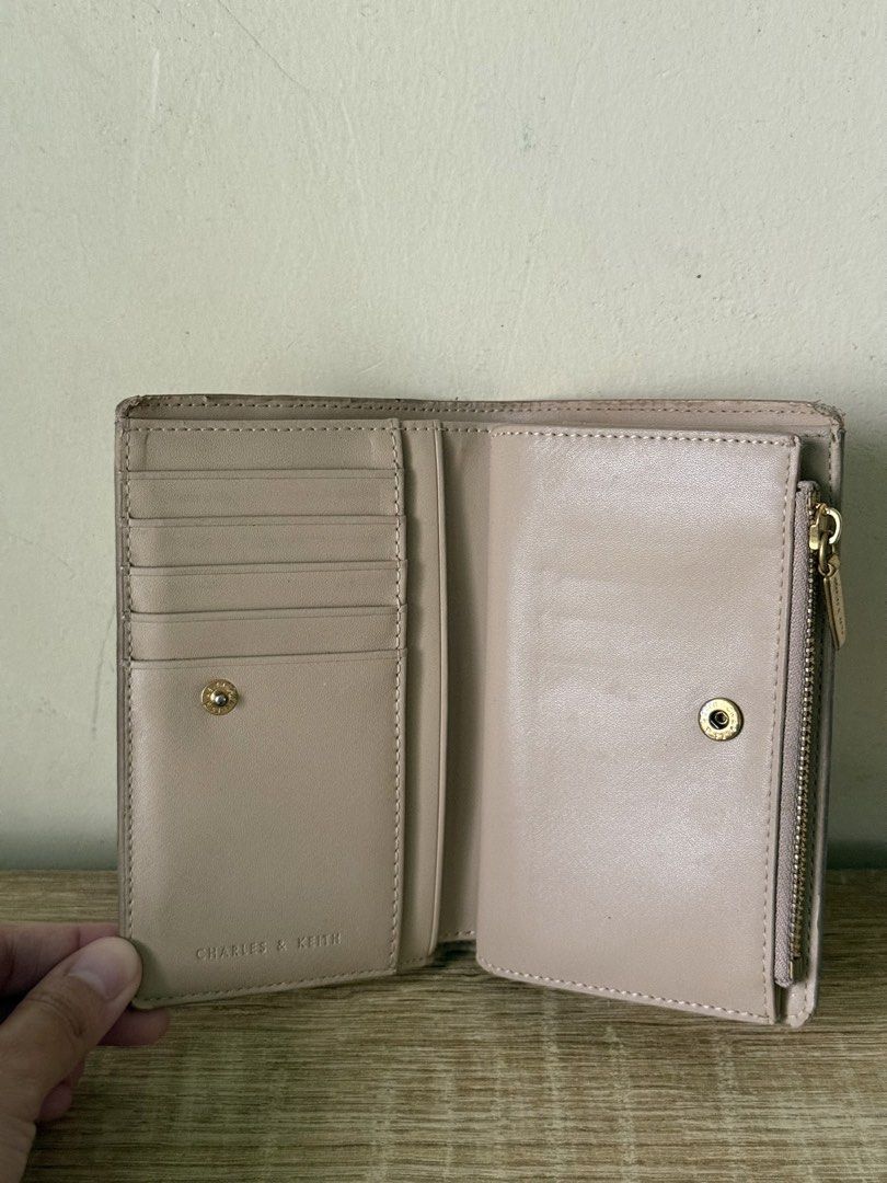 Charles & Keith Nude Wallet (Category: Wallets & Card holders) located in Caloocan City. Submitted by _declutterbym (Listing ID 1460435997, Image 3). Description: - Brand: Charles & Keith - Color: Beige/Nude - Design: Tri-fold - Features: Multiple card slots, zip compartment for coins/cash - Size: Small and compact, fits easily in any bag - Ideal for: Everyday use, keeping essentials organized.