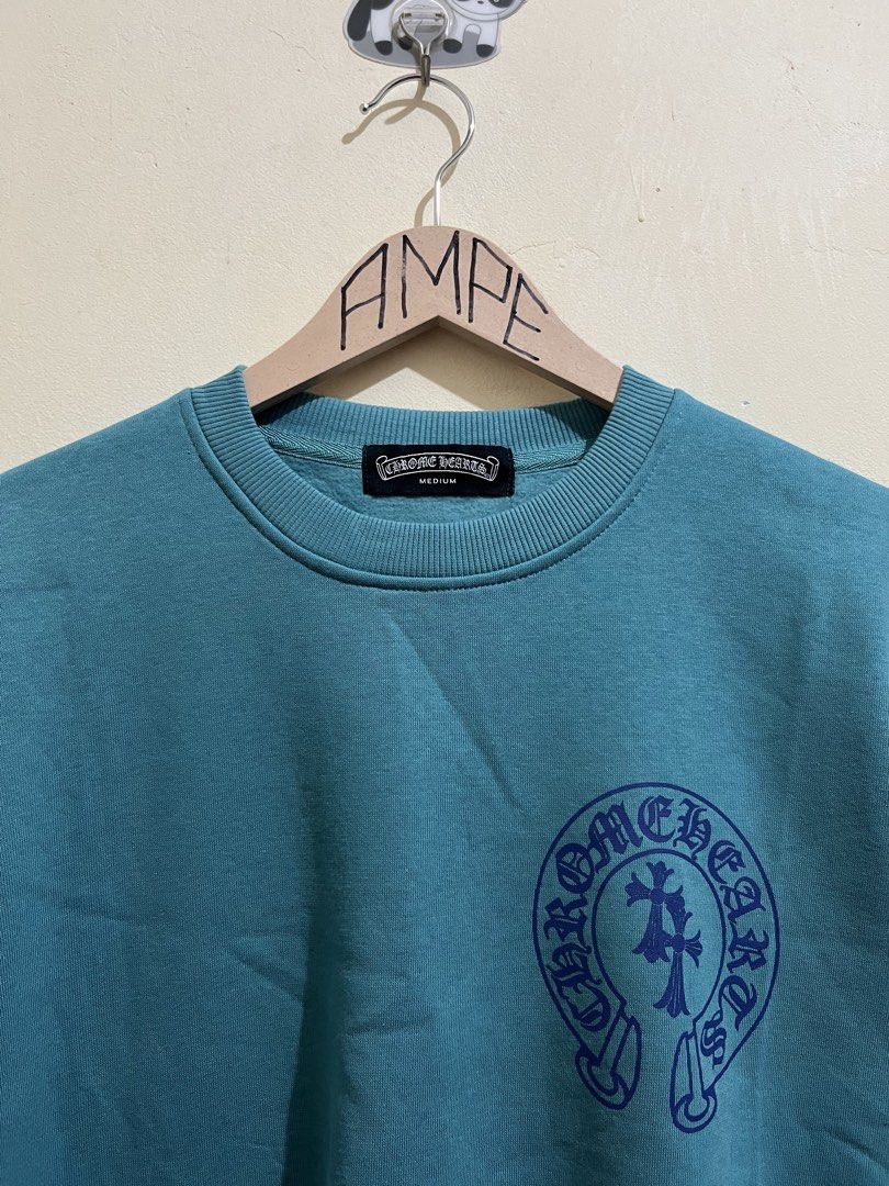 Chrome Hearts Horseshoe Logo Sweatshirt Teal Medium (Category: Coats, Jackets and Outerwear) located in Manila. Submitted by juspheroca82034 (Listing ID 1460388861, Image 3). Description: - Teal Chrome Hearts sweatshirt - Size: Medium - Front: Horseshoe logo - Back: Double crosses - Left Sleeve: Small Chrome Hearts logo - Measurements: 21" pit to pit, 27" length.