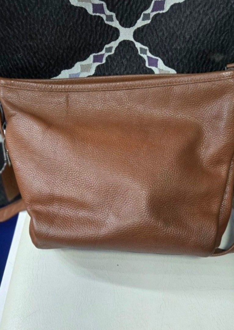 Coach Brown Leather Shoulder Bag (Category: Luxury Bags & Wallets) located in Quezon City. Submitted by affordabags_cd (Listing ID 1460422529, Image 2). Description: - Brand: Coach - Material: Brown pebbled leather - Closure: Zip top - Interior: Fabric lining with Coach branding patch - Origin: Made in Vietnam - Style: Great everyday shoulder bag.