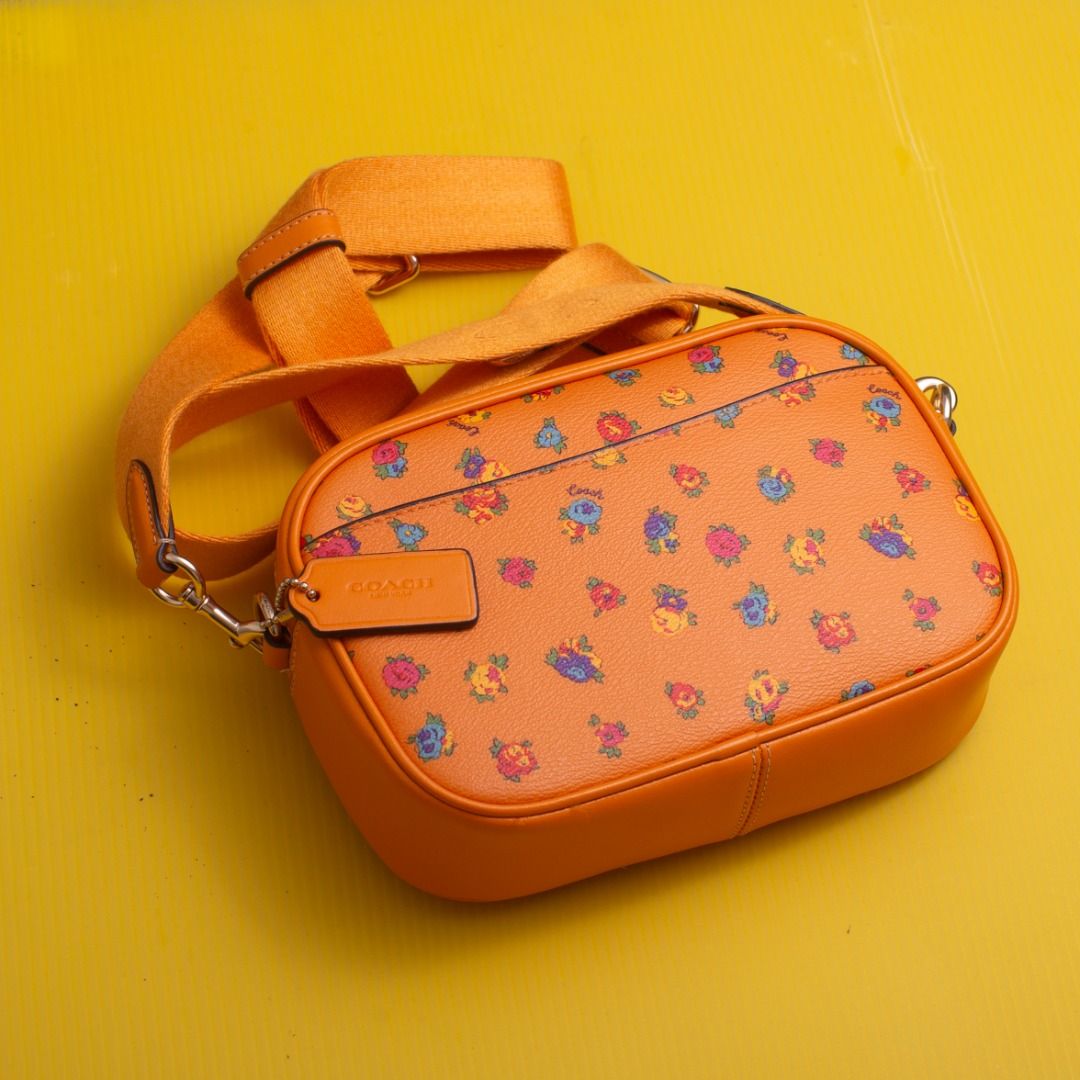 Coach Mini Jamie Camera Bag (Category: Cross-body Bags) located in Quezon City. Submitted by stableshutterstudios (Listing ID 1460458701, Image 2). Description: Authentic good as new, Coach Mini Jamie Camera Bag in a vibrant orange colorway featuring an all-over multi-color floral print and matching orange adjustable canvas strap. Compact, lightweight, and stylish—perfect for daily use or casual outings. Features: Secure zip-top closure, inside s