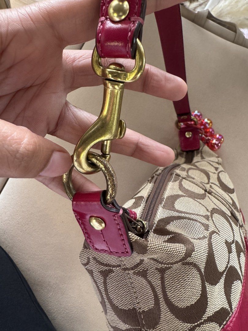 Coach Monogram Canvas & Pink Leather Shoulder Bag (Category: Luxury Bags & Wallets) located in San Pedro. Submitted by kianacrngn (Listing ID 1460395724, Image 2). Description: - Authentic Coach monogram shoulder bag - Stylish pink leather trim - Vibrant, colorful striped interior lining - Durable brass-toned hardware - Adorable beaded charm attached to the strap - Secure zipper closure - Interior features a Coach logo and serial number leather p