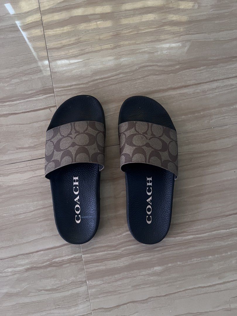 Coach Monogram Slides Sandals (Category: Slippers and slides) located in Malolos. Submitted by urgoodsfrommls (Listing ID 1460395617, Image 1). Description: - Authentic Coach monogram slides - Classic black footbed with white COACH lettering - Soles feature the signature Coach logo pattern - Size: 7 US / 38 EU - Ideal for casual wear and everyday comfort.