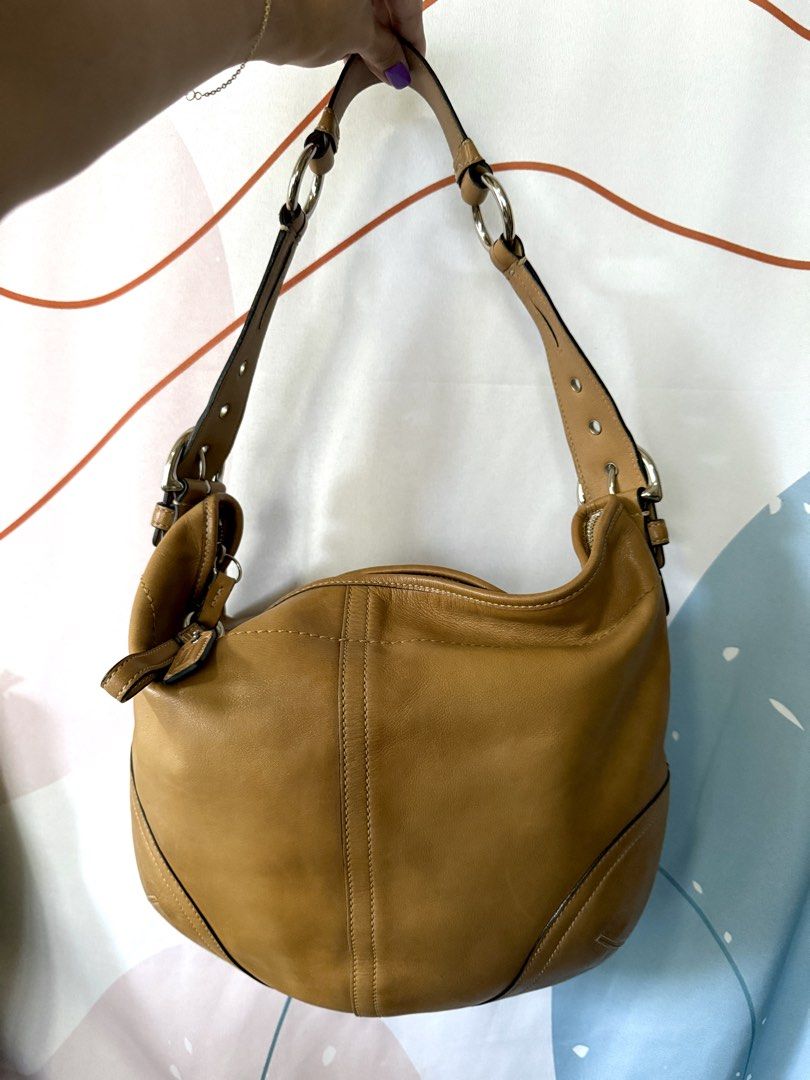 Coach Soho Hobo Shoulder Bag (Tan) (Category: Luxury Bags & Wallets) located in Quezon City. Submitted by elysejuan (Listing ID 1460366635, Image 1). Description: - ✨ RARE ✨ Authentic Coach tan leather hobo bag - Made from soft, glove-tanned cowhide - Features silver hardware details - Adjustable shoulder strap with buckle - Interior lined with Coach logo - Serial number: NK04S-3651.