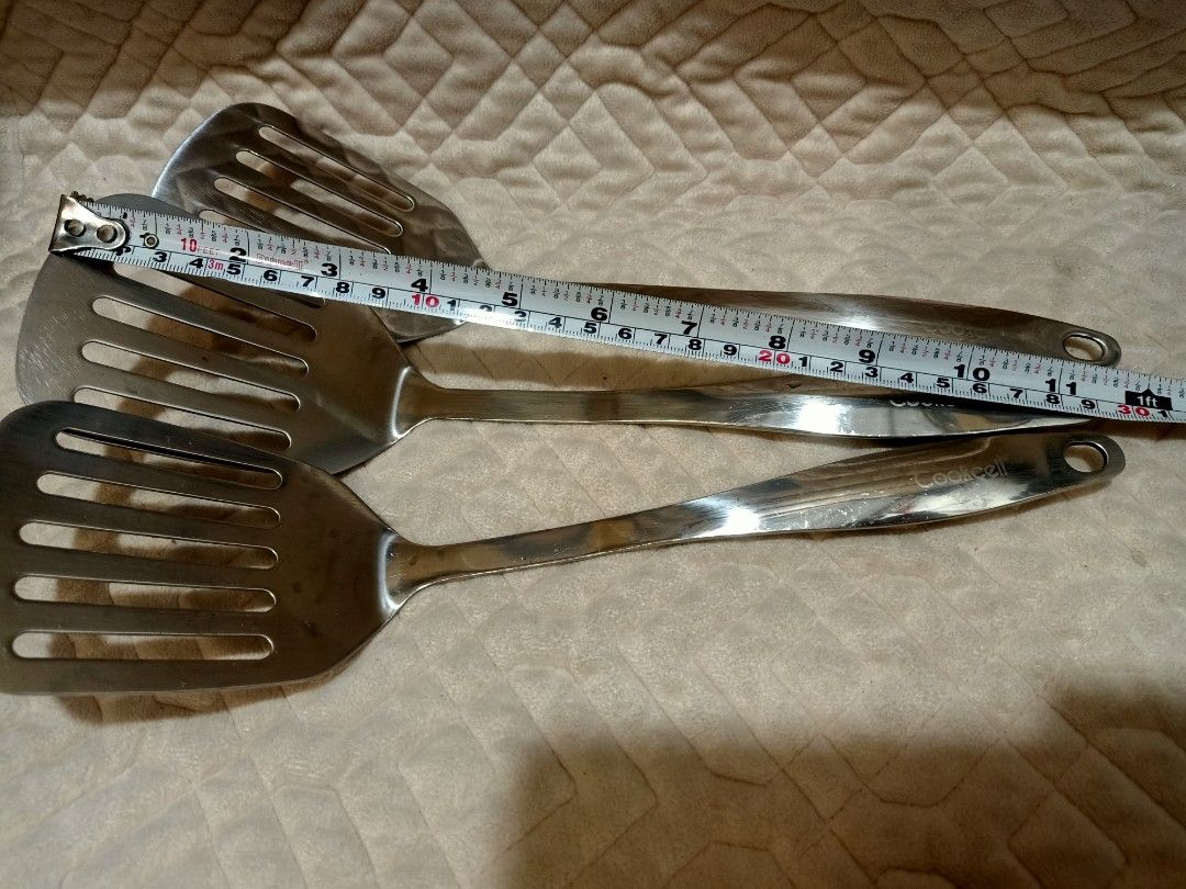Cookcell stainless steel turner set (Category: Cookware & Accessories) located in Pasig City. Submitted by urdal01 (Listing ID 1460359657, Image 3). Description: Cookcell stainless steel slotted kitchen spatula (or turner) with a glossy metal handle featuring a hanging hole..