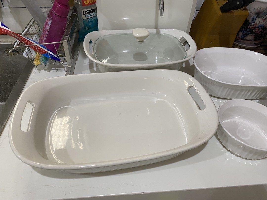 Corningware White Ceramic Baking Dishes with Glass Lids (Category: Bakeware) located in Mendez-Nunez. Submitted by BeYOUtifulStuffsGalore (Listing ID 1460503846, Image 1). Description: - Set of 7 white ceramic baking dishes - Includes large rectangular dish with glass lid - Includes smaller round dish with glass lid - Includes medium oval dish - Includes small round dish - Easy to clean - Ideal for casseroles, roasts, and desserts.