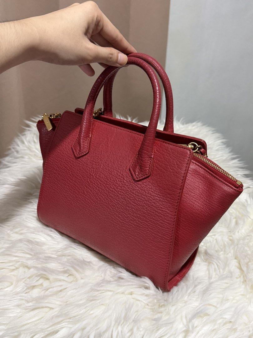 Couronne Trapeze Handbag Sling (Category: Cross-body Bags) located in Marikina City. Submitted by welllovedbycarina (Listing ID 1460502495, Image 2). Description: Original Couronne 🍒 Preowned from Korea The color is red orange with gold tone hardwares Cute size! Dimensions: 22cm x 16cm x 9cm BAG CONDITION • Overall Condition: Excellent • Leather/Material: Excellent • Corners & Edges: Excellent • Handles & Straps: Excellent • Hardware: Very good,