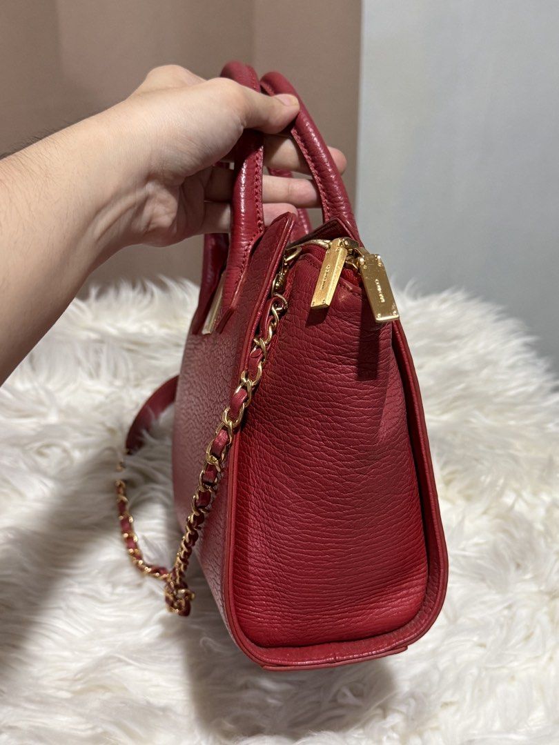 Couronne Trapeze Handbag Sling (Category: Cross-body Bags) located in Marikina City. Submitted by welllovedbycarina (Listing ID 1460502495, Image 3). Description: Original Couronne 🍒 Preowned from Korea The color is red orange with gold tone hardwares Cute size! Dimensions: 22cm x 16cm x 9cm BAG CONDITION • Overall Condition: Excellent • Leather/Material: Excellent • Corners & Edges: Excellent • Handles & Straps: Excellent • Hardware: Very good,
