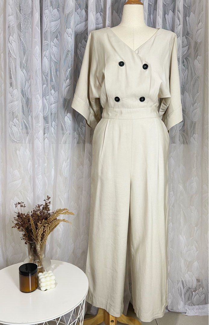 Cream Wide-Leg Jumpsuit (Category: Jumpsuits) located in Manila. Submitted by maison_marie (Listing ID 1460456964, Image 1). Description: Elegant cream-colored wide-leg jumpsuit featuring a sophisticated V-neckline. Size: Medium on tag ¾-length sleeves Flowing wide-leg pants Side zipper closure Twi functional side pockets. Minor imperfections: 2. Buttonhole stitching shows minor fraying/wear, but it is not very noticeable when worn and buttoned u