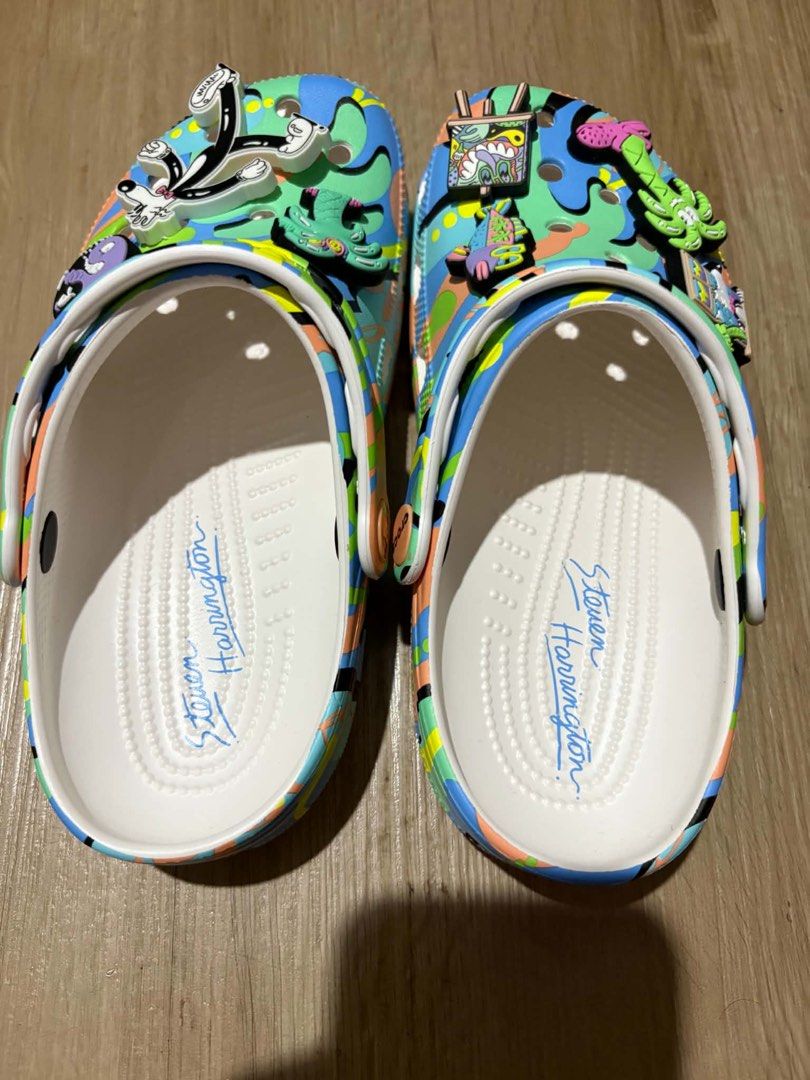 Crocs Steven Harrington (Category: Slippers and slides) located in Quezon City. Submitted by larenaxoxo (Listing ID 1460485252, Image 2). Description: - Limited edition Crocs designed by Steven Harrington. - Features a vibrant, abstract artistic pattern. - Comes with unique Jibbitz charms: fish, palm tree, and a cartoon character. - Insoles are personally signed by Steven Harrington. - Perfect for a stylish and personalized statement piece..