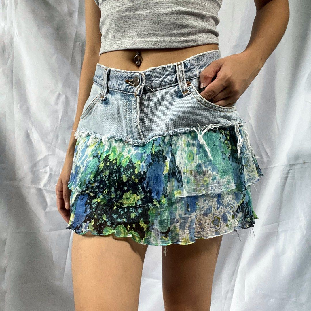 Distressed Denim Ruffle Mini Skirt Blue Floral (Category: Skirts) located in Manila. Submitted by demi.rewears (Listing ID 1460314367, Image 2). Description: Cute distressed denim mini skirt with a tiered floral ruffle hem. Features raw hem, button/zip closure, and front pockets. Perfect for casual or festival wear. Waist (Flat): 14 inches (28” circumference) Length: 12.5 inches (Micro/Mini skirt length).