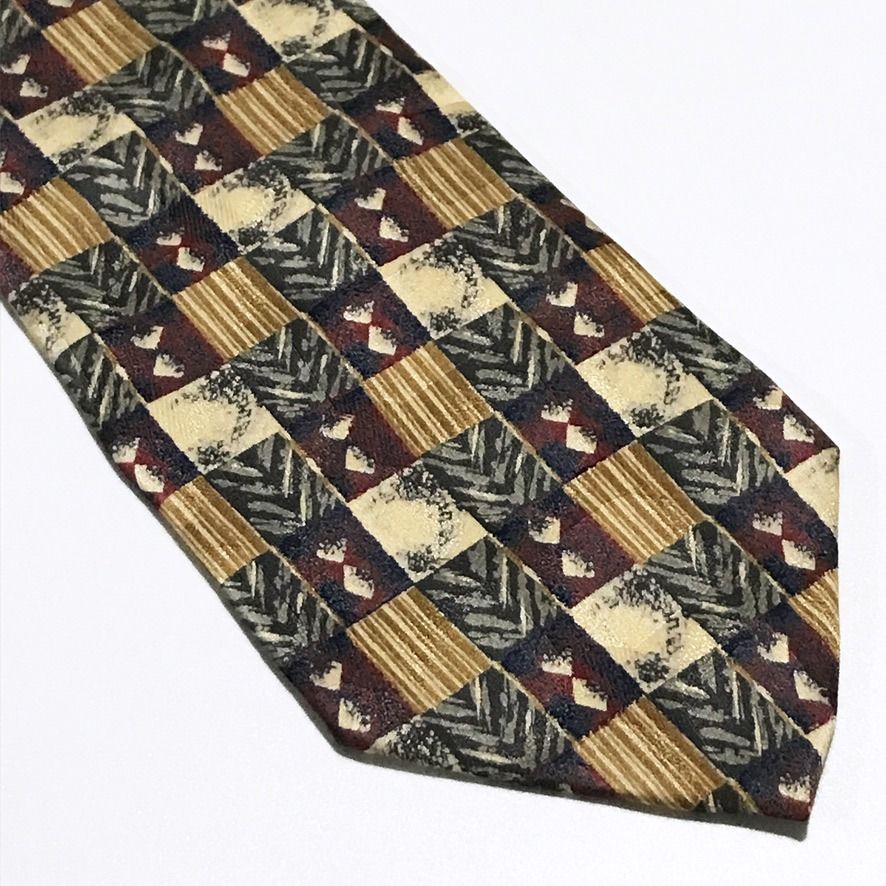 Full Mark Vintage Abstract Pattern Neck Tie (Category: Ties) located in Taguig. Submitted by retrogaze (Listing ID 1460395671, Image 2). Description: This vintage 100% silk necktie by Full Mark features a multi-toned base with a smooth, soft-sheen finish. The body displays a bold, geometric patchwork grid pattern combining alternating tiles of pinstripes, chevron weaves, speckled textures, and diamond motifs in warm earth tones of tan, gold, deep