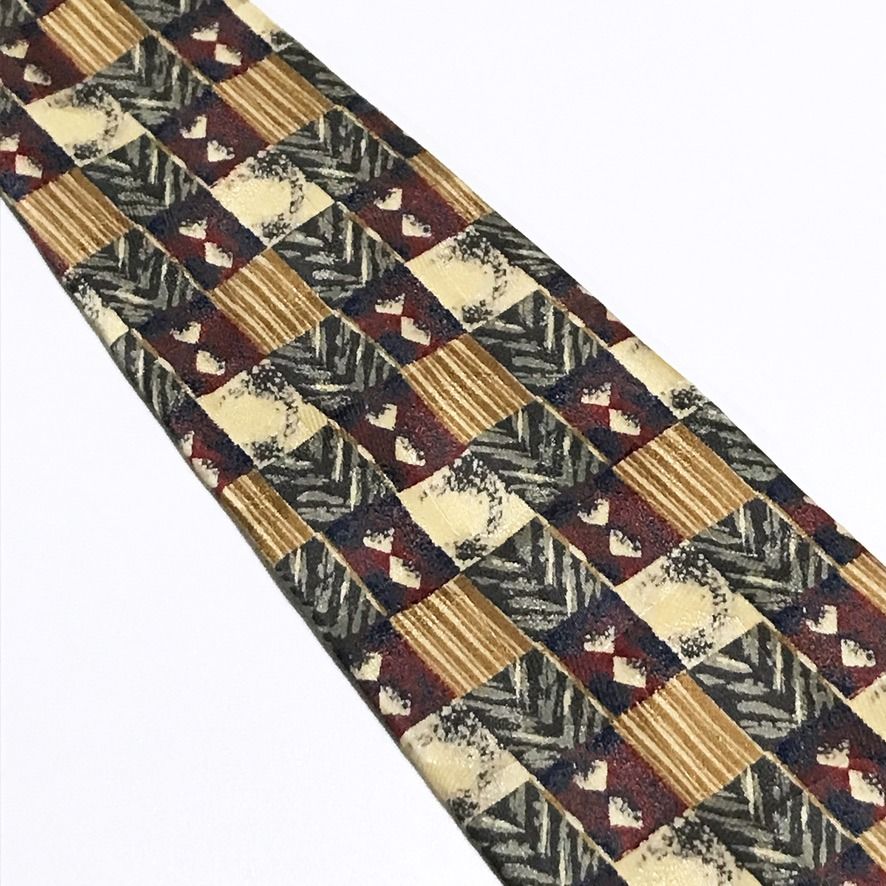 Full Mark Vintage Abstract Pattern Neck Tie (Category: Ties) located in Taguig. Submitted by retrogaze (Listing ID 1460395671, Image 3). Description: This vintage 100% silk necktie by Full Mark features a multi-toned base with a smooth, soft-sheen finish. The body displays a bold, geometric patchwork grid pattern combining alternating tiles of pinstripes, chevron weaves, speckled textures, and diamond motifs in warm earth tones of tan, gold, deep