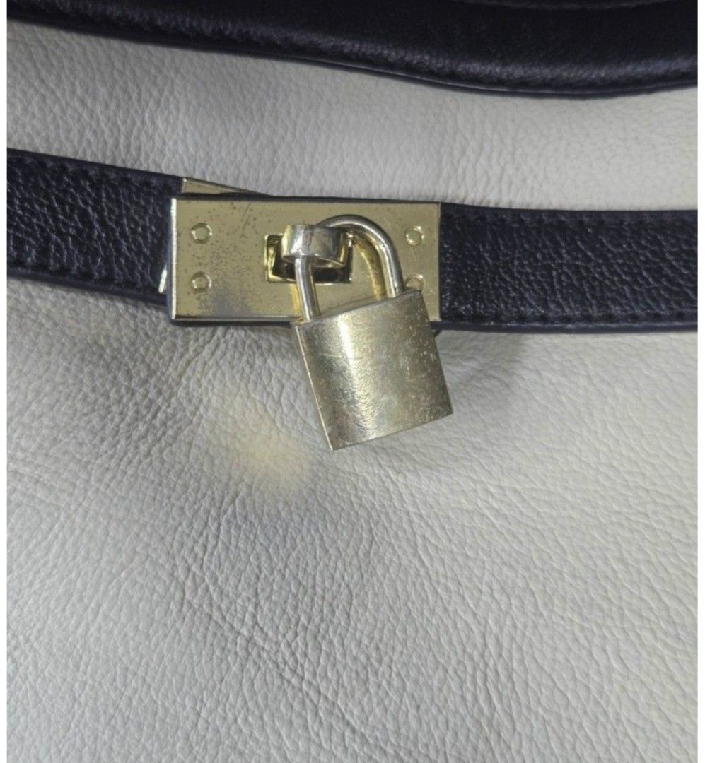 GEIGER Two-Tone Leather Handbag with Lock (Category: Other Accessories) located in Quezon City. Submitted by affordabags_cd (Listing ID 1460425898, Image 2). Description: - Stylish two-tone leather handbag in cream and black. - Features a prominent gold-tone lock closure on the front strap. - Secure top zip closure for your belongings. - Comfortable double top handles for easy carrying. - Elegant GEIGER logo subtly displayed on the front. - Ample