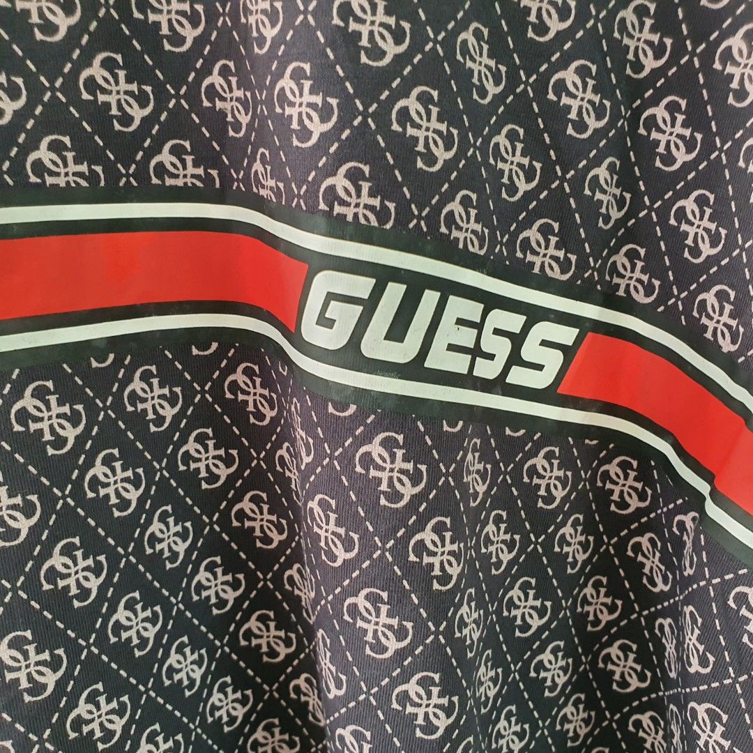 Guess All Over Print T-Shirt (Category: Tshirts & Polo Shirts ) located in Tarlac. Submitted by resaleclub (Listing ID 1460443511, Image 2). Description: - Guess all-over monogram print t-shirt - Features classic Guess logo across the chest - Red and white stripe detailing - Small red Guess triangle logo on the sleeve - Measurements: Width 23", Length 29" - please check photos for stain, discoloration, pinhole or mending. Bawal po sa maselan.