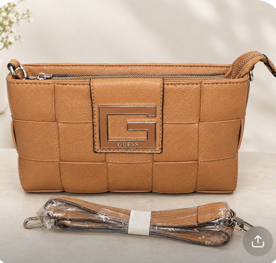 Guess Crossbody Bag Tan (Category: Cross-body Bags) located in Manila. Submitted by vsballeras1984 (Listing ID 1460469138, Image 1). Description: - Top GradeTan Guess crossbody bag - Chic woven texture all over - Main zippered compartment for secure storage - Convenient front zippered pocket - Detachable strap for versatile wear - Elegant silver hardware details.
