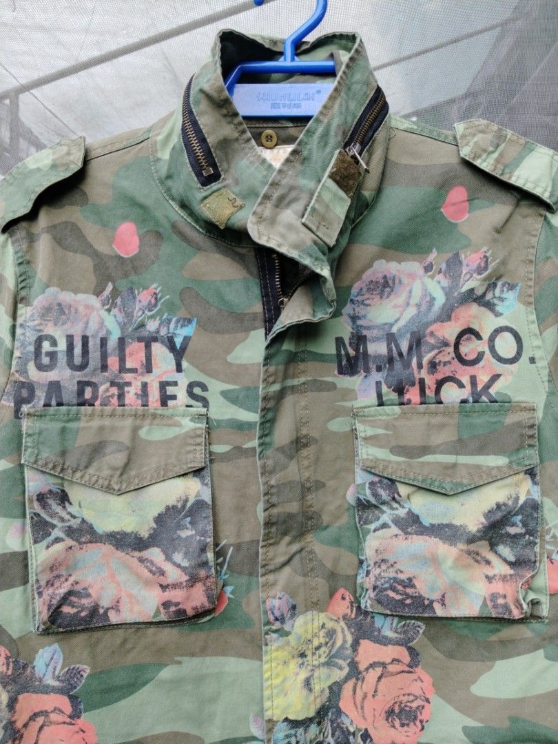 Guilty Parties Camo Floral Jacket (Category: Coats, Jackets and Outerwear) located in Legazpi City. Submitted by genobecollectives (Listing ID 1460437537, Image 3). Description: - Unique camo jacket with a stylish floral print. - Features 'Guilty Parties' and 'M.M. Co. Luck' graphic details. - Multiple functional pockets on the front. - Secure zip and button closure. - Made by Skyeye, a brand established in 1993. 800 add sf 22 x 30 .