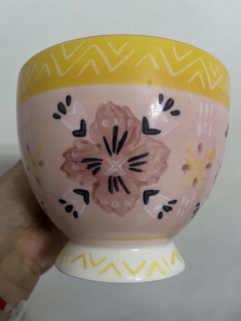 Hand-painted Floral Ceramic Mug with Handle (Category: Coffee & Tea Tableware) located in Dasmarinas. Submitted by purpleboxmidori (Listing ID 1460471828, Image 3). Description: - Adorable ceramic mug with a charming hand-painted floral design. - Features a lovely pink base with cheerful yellow accents. - Contrasting black handle for a stylish touch. - Perfect for enjoying your morning coffee or tea. - Generous size: approximately 10cm in diamete
