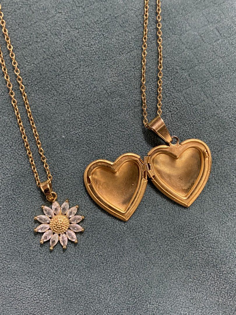 Heart Locket & Daisy/Sunflower Necklace (Category: Necklaces) located in Quezon City. Submitted by vchristineandrea (Listing ID 1460401806, Image 2). Description: - Set of two gold necklaces - Includes a heart locket (perfect for photos/keepsakes) - Includes a delicate chain with a sparkly daisy/sunflower pendant - Both chains are a nice, versatile length - Great for layering or wearing separately - Sold as a set.