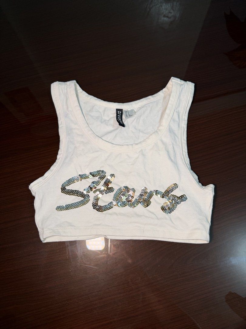 H&M Divided White Crop Top with Sequins "Stars" (Category: Others Tops) located in Quezon City. Submitted by nakii_ko (Listing ID 1460314520, Image 1). Description: - White H&M Divided crop top - Features 'Stars' spelled out in sparkly sequins - Sleeveless design - Versatile for casual or dressed-up looks - Size: Small NEVER USED!! Natambak lang eversince bought.