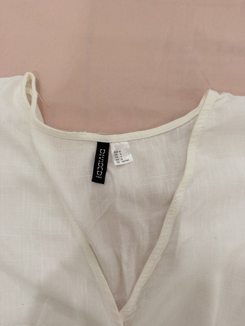 H&M DIVIDED WRAP CROP TOP (Category: Blouses) located in Abulug. Submitted by joysmithznjo (Listing ID 1460427178, Image 2). Description: - White wrap crop top from H&M Divided - Made with a comfortable linen and viscose blend - Features stylish flutter sleeves - Adjustable tie-up sides for a perfect fit - Flattering V-neckline - Versatile for casual outings or dressing up - Easily pairs with jeans or skirts.