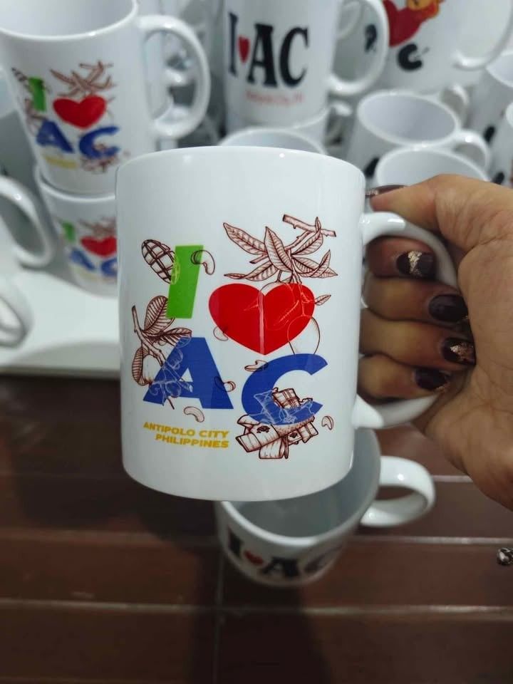I ❤️ AC Antipolo City PH Mug (Category: Coffee & Tea Tableware) located in Caloocan City. Submitted by majehjembo8 (Listing ID 1460371277, Image 3). Description: P100.00 each design - White ceramic mug - Features "I ❤️ AC Antipolo City, PH" design - Ideal for coffee or tea - Makes a great souvenir from Antipolo City - Sturdy handle for a comfortable grip - Perfect gift for friends and family who love Antipolo.