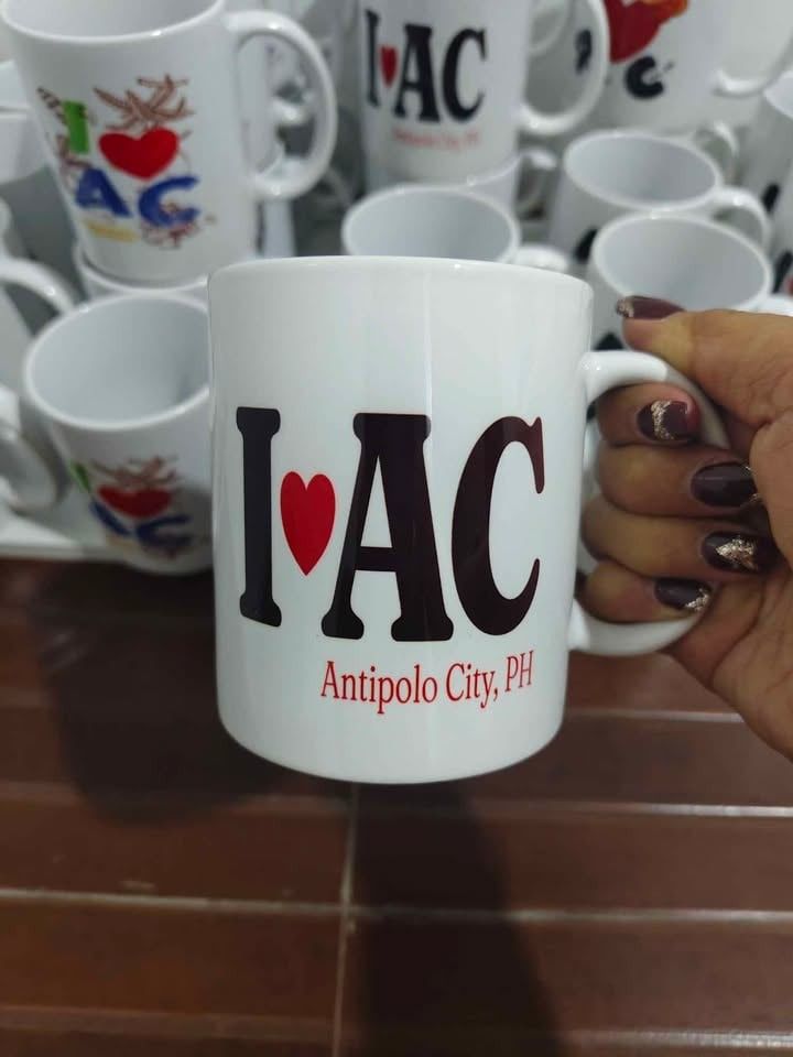 I ❤️ AC Antipolo City PH Mug (Category: Coffee & Tea Tableware) located in Caloocan City. Submitted by majehjembo8 (Listing ID 1460371277, Image 1). Description: P100.00 each design - White ceramic mug - Features "I ❤️ AC Antipolo City, PH" design - Ideal for coffee or tea - Makes a great souvenir from Antipolo City - Sturdy handle for a comfortable grip - Perfect gift for friends and family who love Antipolo.