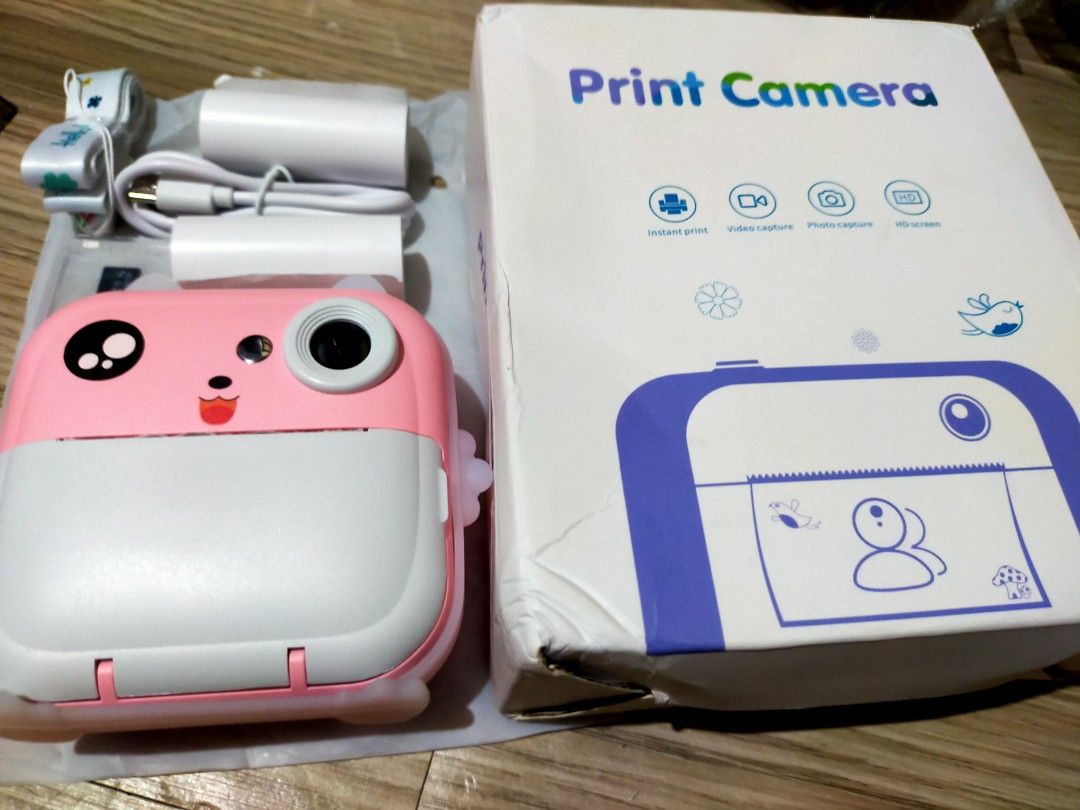 Instant print camera (Category: Cameras) located in Manila. Submitted by luxbox3467 (Listing ID 1460361709, Image 2). Description: - Instant print camera, LIOTOG Q5 model - Adorable pink design - Prints photos instantly, no ink required - Features 800mAh battery - Supports video recording - Includes printing app and games - Easy to use for all ages - Sd card - Lanyard.