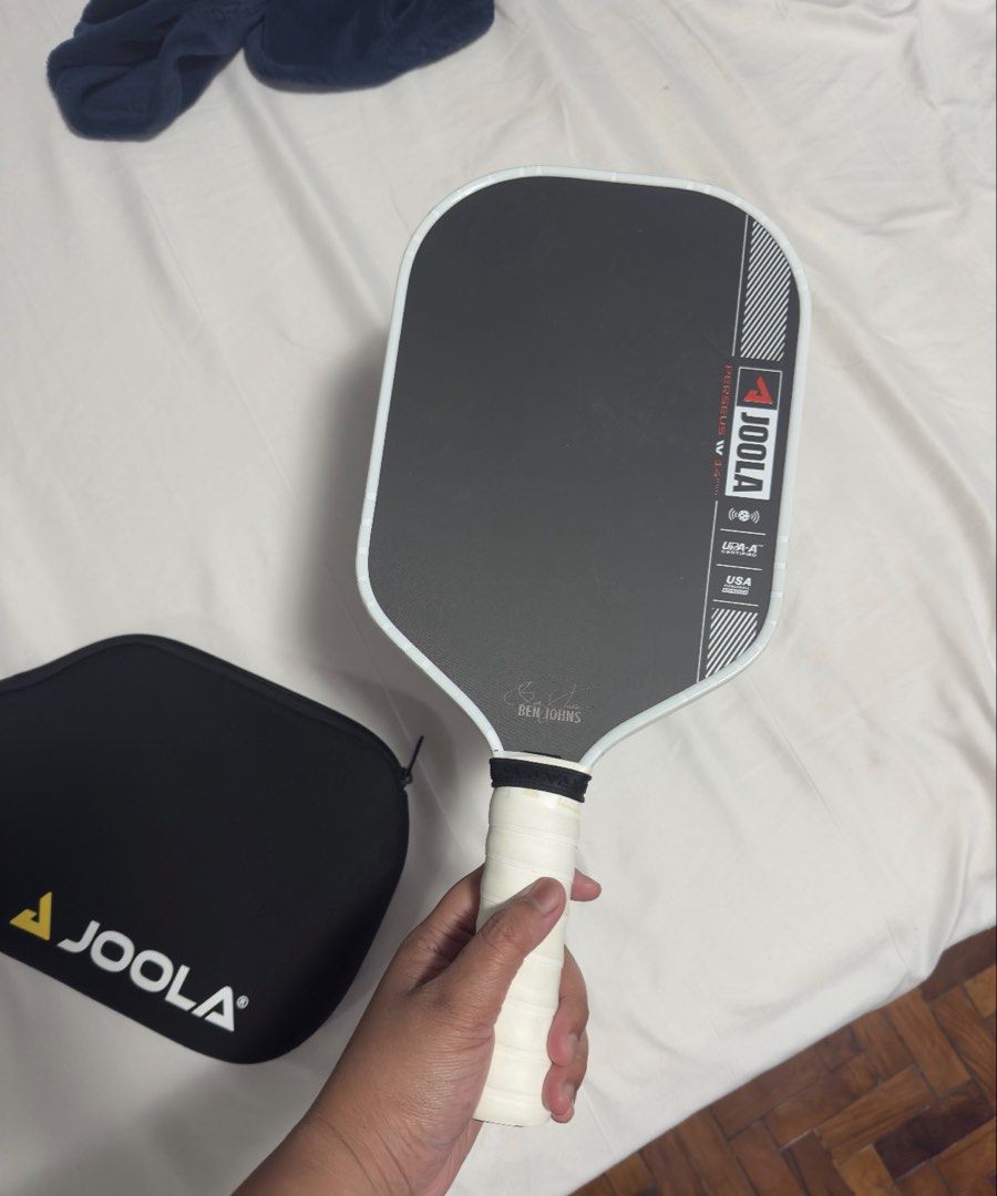 Joola Pro IV Perseus elongated 14mm (Category: Racket and Ball Sports) located in Pasig City. Submitted by mswise (Listing ID 1460457660, Image 1). Description: The JOOLA Ben Johns Perseus Pro IV is a premium, high-performance pickleball paddle designed for advanced and professional players. It is the signature model for world number one Ben Johns, combining an elongated shape with explosive power and precise ball placement. New handle grips and 