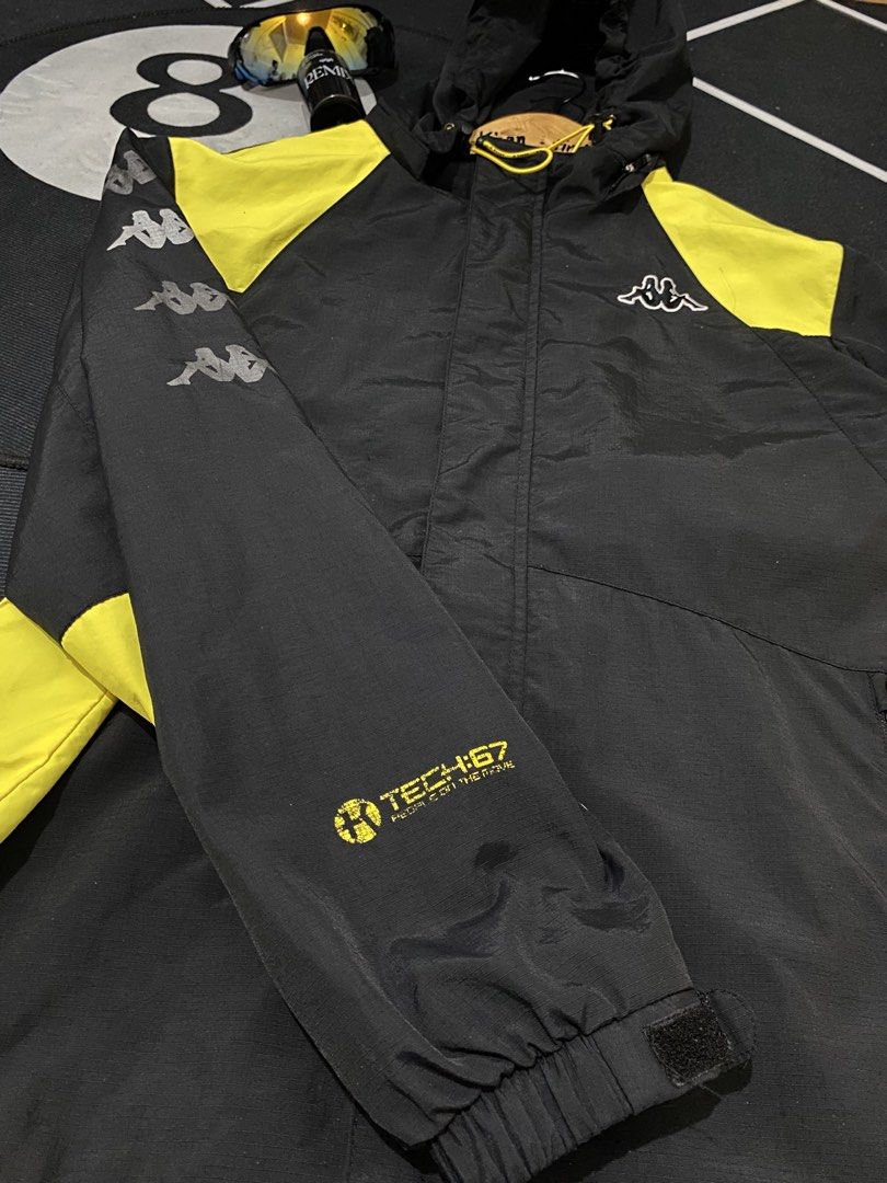 Kappa Track Jacket Black Yellow Logo Tech (Category: Coats, Jackets and Outerwear) located in Cateel. Submitted by khan.find_ (Listing ID 1460329584, Image 3). Description: - Stylish black and yellow Kappa jacket - Features iconic Kappa logo on chest and sleeves - 'K TECH' detail on the front - Hooded design with adjustable yellow drawstrings - Elasticated cuffs and hem for a snug fit - Ideal for casual outings or athletic activities.