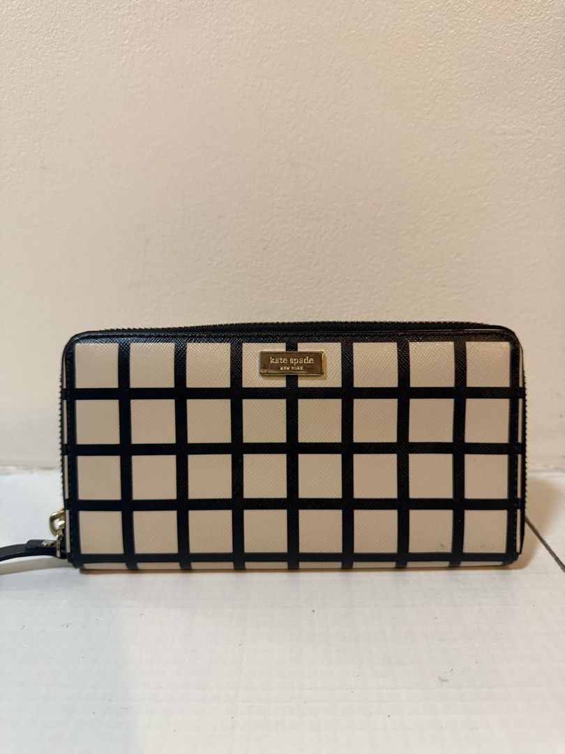 Kate Spade New York Zip Around Wallet (Category: Wallets & Card holders) located in Pasig City. Submitted by laineeo (Listing ID 1460335146, Image 1). Description: - Authentic Kate Spade zip-around wallet - Stylish beige with black grid pattern - Elegant gold-tone hardware and logo plate - Convenient attached wrist strap - Spacious interior for cards and cash - Ideal for everyday organization and use.