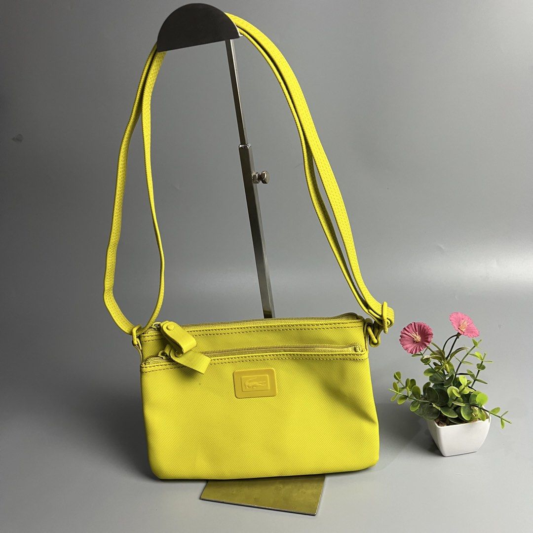 Lacoste Yellow Crossbody Bag (Category: Cross-body Bags) located in Bago City. Submitted by g___shop (Listing ID 1460437969, Image 2). Description: - Bright yellow Lacoste crossbody bag - Features two zippered compartments on the front - Adjustable strap with embossed Lacoste logo on hardware - Ideal for everyday use or travel - Small and compact design.