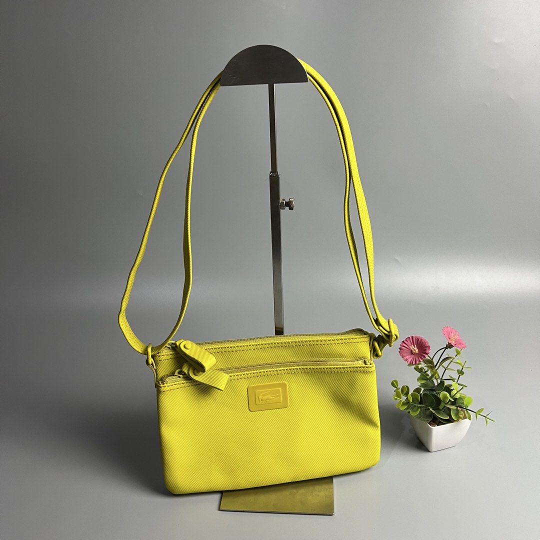 Lacoste Yellow Crossbody Bag (Category: Cross-body Bags) located in Bago City. Submitted by g___shop (Listing ID 1460437969, Image 1). Description: - Bright yellow Lacoste crossbody bag - Features two zippered compartments on the front - Adjustable strap with embossed Lacoste logo on hardware - Ideal for everyday use or travel - Small and compact design.