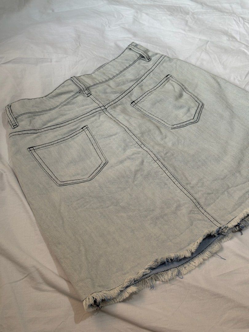 Light Wash Distressed Denim Mini Skirt (Category: Skirts) located in Pasay City. Submitted by nicoletlntn_ (Listing ID 1460480867, Image 2). Description: - Light wash denim mini skirt - Frayed hem and distressed front details - Classic 5-pocket styling - Button and zip closure - Versatile for casual outfits with t-shirts or crop tops.
