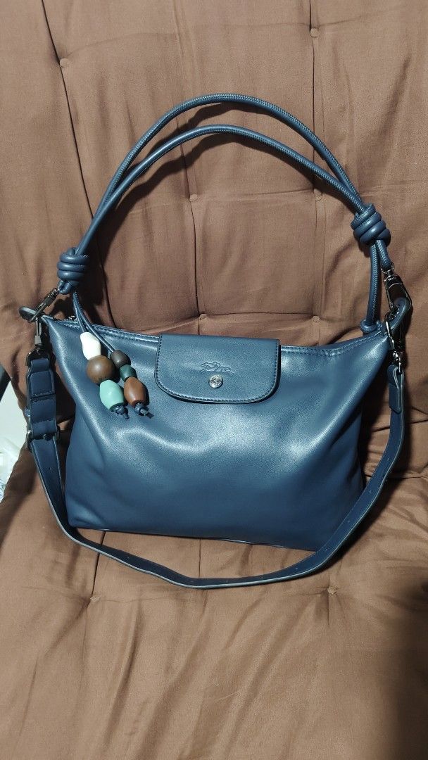 Longchamp Blue Leather (Category: Luxury Bags & Wallets) located in Antipolo. Submitted by robannrave98496 (Listing ID 1460404039, Image 2). Description: - longchamp navyblue stylish blue leather handbag - Knotted top handles - Flap closure with snap button - Secure top zipper closure - Detachable shoulder strap included - Adorable beaded charm accent - Ideal size for daily essentials.