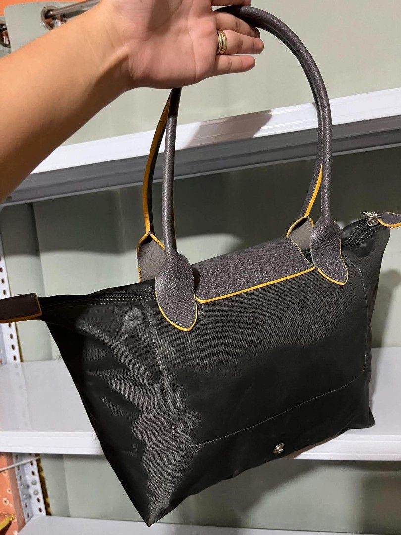 Longchamp Le Pliage Neo Tote Bag (Category: Luxury Bags & Wallets) located in Carmen. Submitted by ar_thrift00 (Listing ID 1460457082, Image 3). Description: - Classic Longchamp tote bag - Color: Black nylon with grey leather trim and yellow accents - Iconic embroidered yellow horse logo - Closure: Zip with snap tab - Ideal for everyday use, travel, or work - Spacious interior - Comfortable handles.