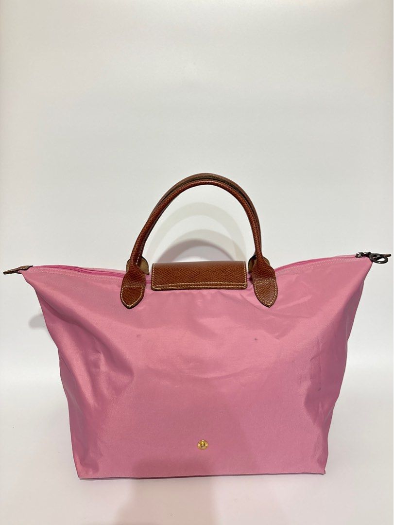 Authentic Longchamp Le Pliage Pink Top Handle Bag (Category: Luxury Bags & Wallets) located in Subic. Submitted by dear.jeveaph (Listing ID 1460419392, Image 2). Description: - Authentic Pink Longchamp Le Pliage Bag - Large Size - Genuine Leather Handles and Trim - Secure Zipper Closure - Ideal Everyday Bag - Minimal dirt stain - Needs wash - Rubs on corners which is normal for a preloved Longchamp Friendly reminder: This is a preloved bag. Pleas