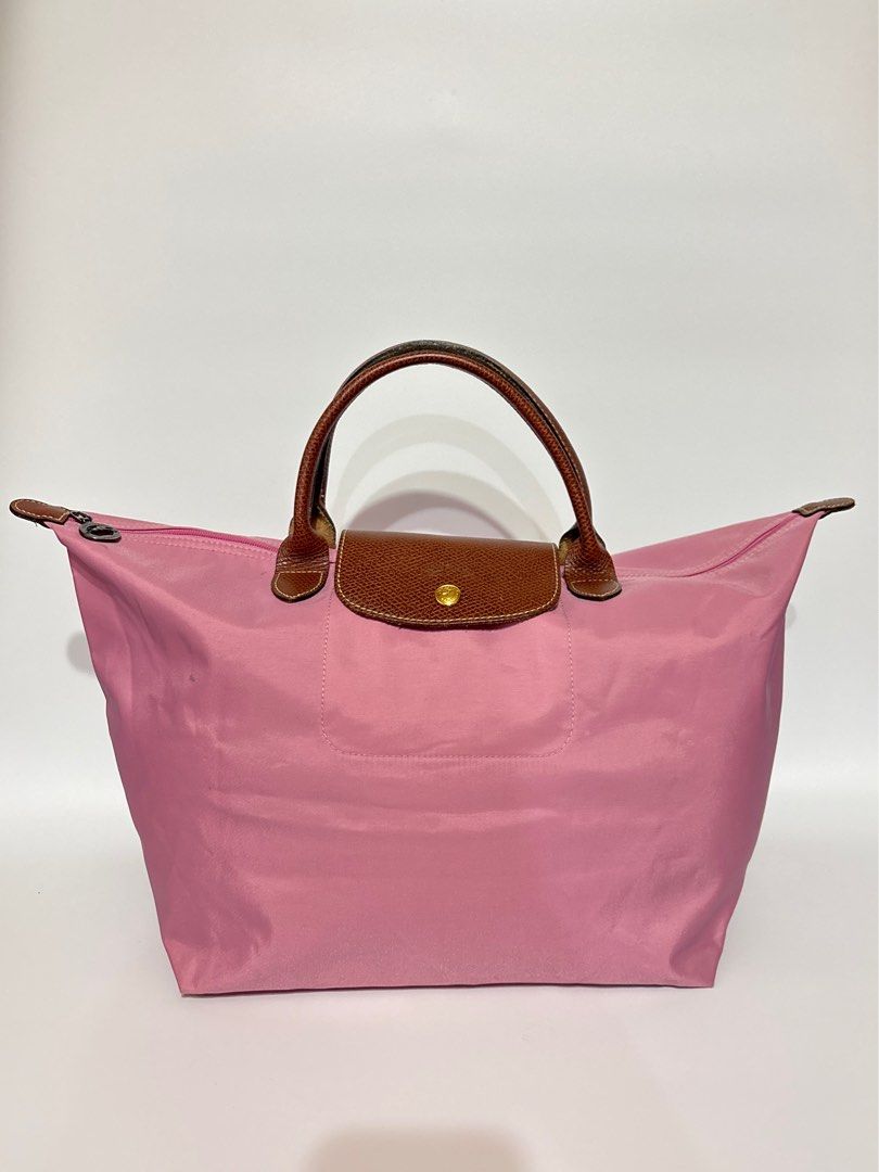 Authentic Longchamp Le Pliage Pink Top Handle Bag (Category: Luxury Bags & Wallets) located in Subic. Submitted by dear.jeveaph (Listing ID 1460419392, Image 1). Description: - Authentic Pink Longchamp Le Pliage Bag - Large Size - Genuine Leather Handles and Trim - Secure Zipper Closure - Ideal Everyday Bag - Minimal dirt stain - Needs wash - Rubs on corners which is normal for a preloved Longchamp Friendly reminder: This is a preloved bag. Pleas
