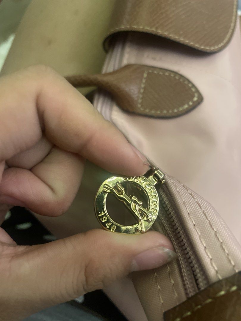 Longchamp Le Pliage Shopping Tote Bag (Category: Luxury Bags & Wallets) located in Manila. Submitted by mikay3laph (Listing ID 1460480026, Image 3). Description: - Authentic Longchamp tote bagbought in hk - Color: Pink nylon with brown leather trim - Iconic embossed horse logo on leather flap - Closure: Snap button and zip with horse zipper pull - Origin: Made in Tunisia - Ideal for everyday use.