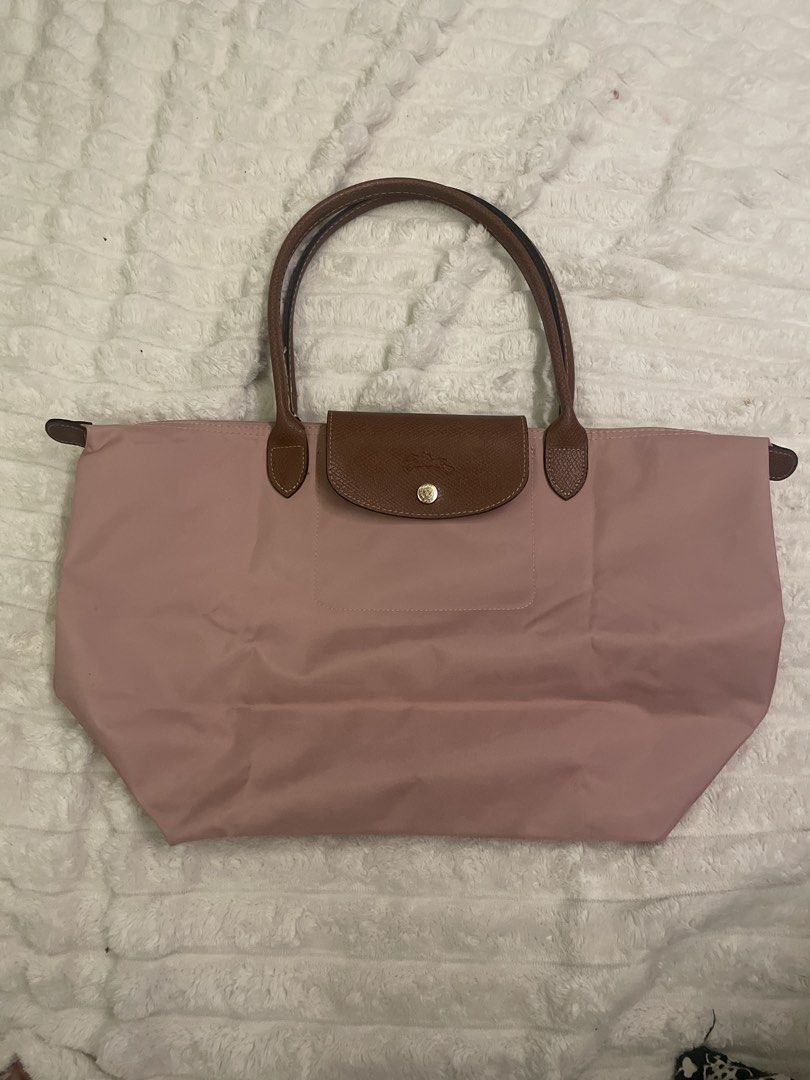 Longchamp Le Pliage Shopping Tote Bag (Category: Luxury Bags & Wallets) located in Manila. Submitted by mikay3laph (Listing ID 1460480026, Image 1). Description: - Authentic Longchamp tote bagbought in hk - Color: Pink nylon with brown leather trim - Iconic embossed horse logo on leather flap - Closure: Snap button and zip with horse zipper pull - Origin: Made in Tunisia - Ideal for everyday use.